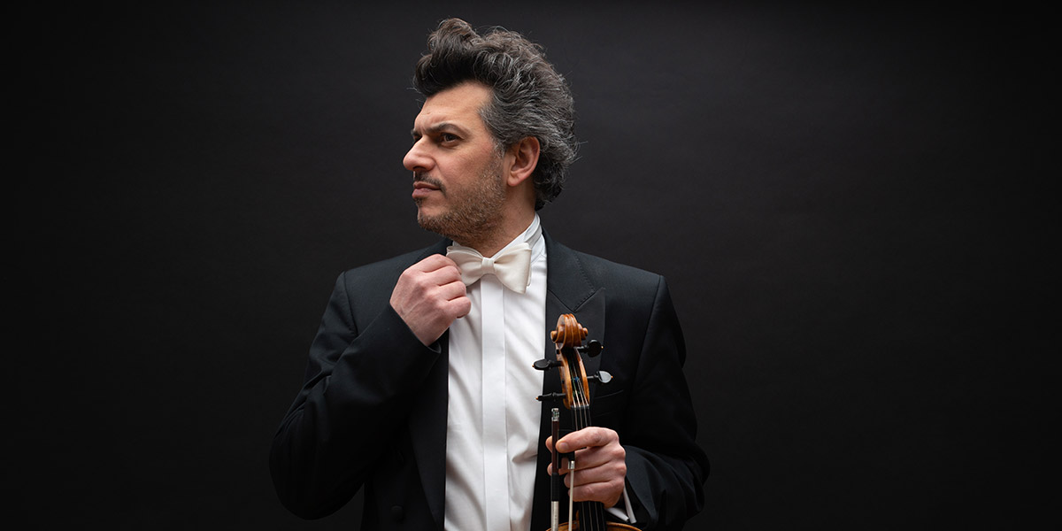 Orchestermusiker in weißem, maßangefertigtem Konzerthemd mit passender Fliege und Blick zur Seite