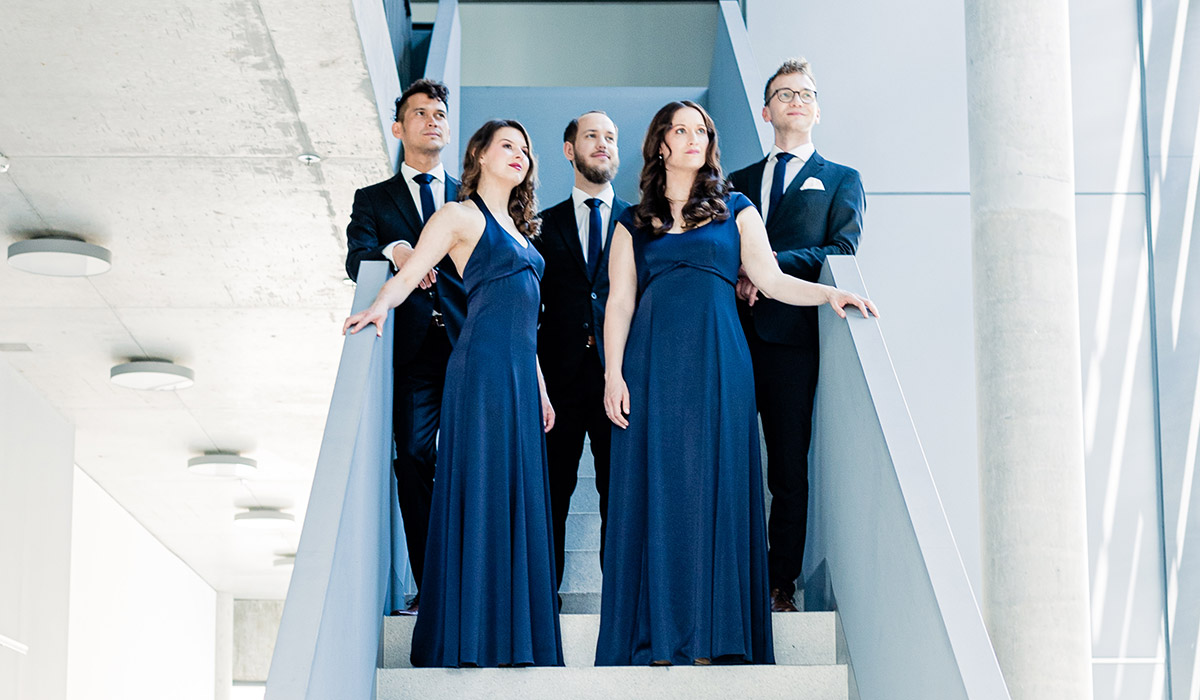 Calmus Ensemble in dunkelblauer Bühnenkleidung von Marillon Couture, stehend
