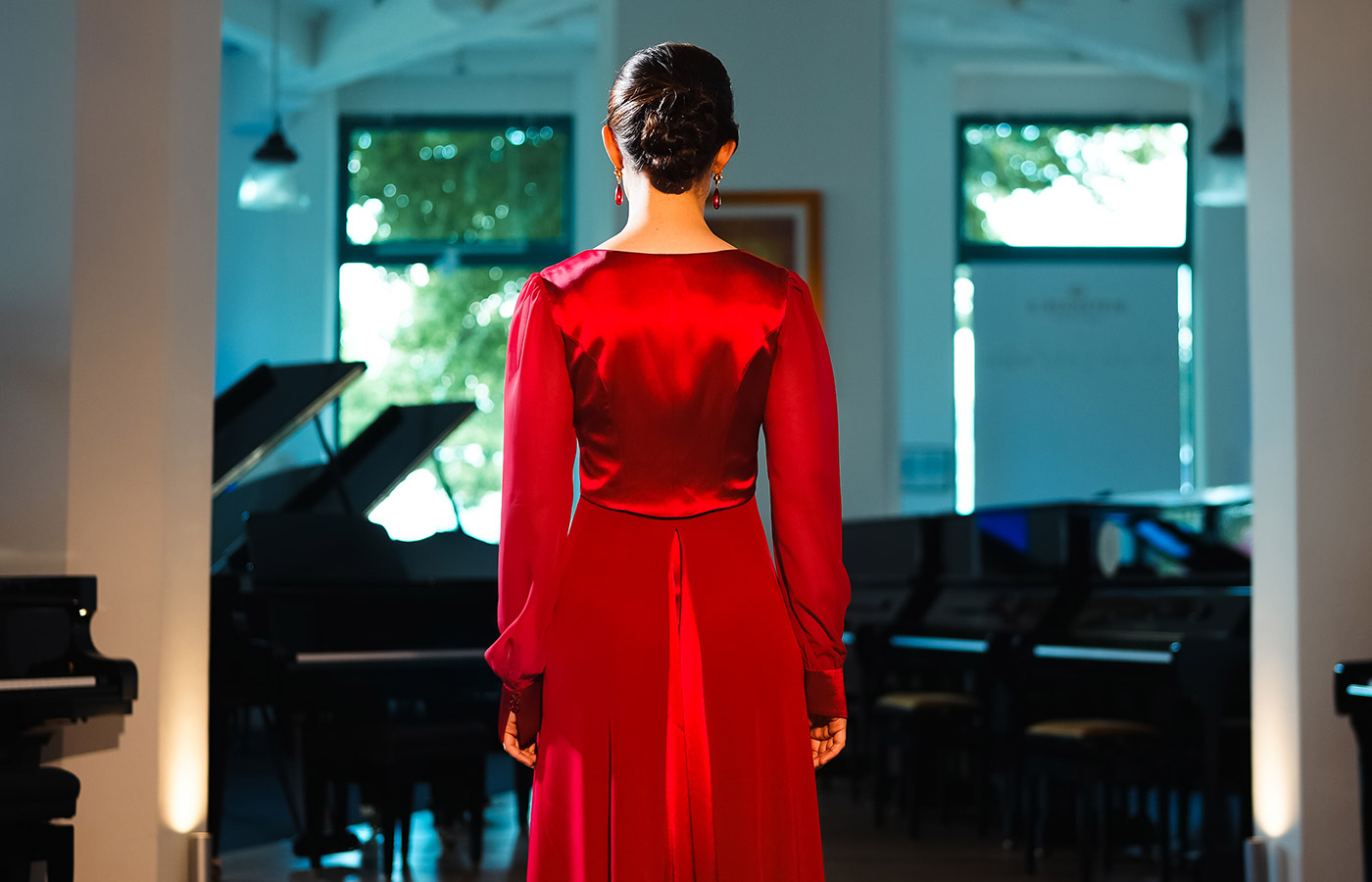 Pianistin Sophie Weidemann in einem roten Konzertkleid von Marillon Couture, Rückansicht
