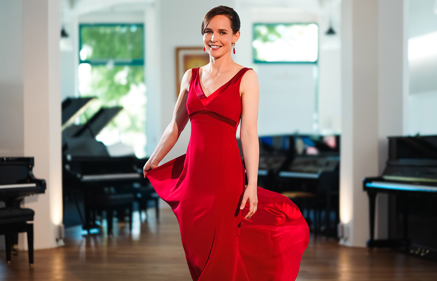 Pianistin Sophie Weidemann in einem roten Konzertkleid von Marillon Couture, stehend
